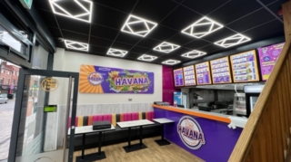 restaurant interior with modern ceiling lights, colourful seating, menu boards, and branded counter